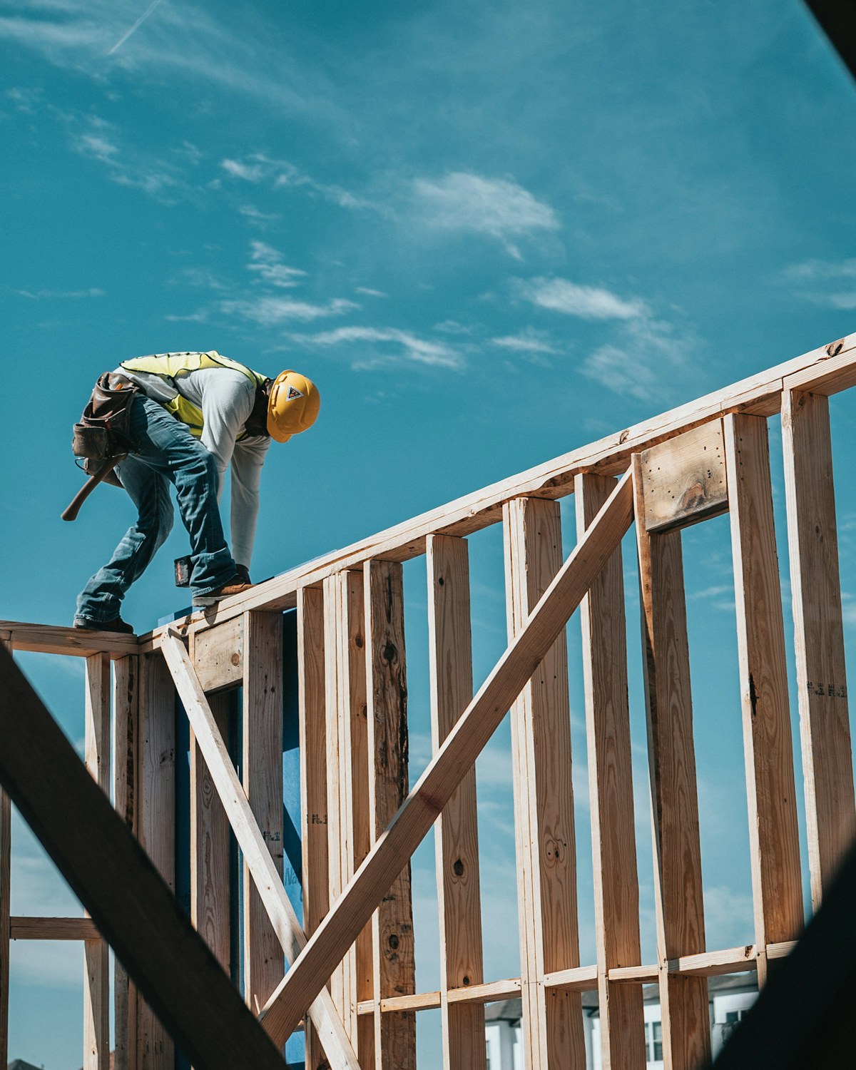 Illustrative photo of a construction worker in a hard hat on a building frame
